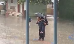 Yağmur altında sırtında torunuyla saygı duruşunda bekleyen dede yürekleri ısıttı