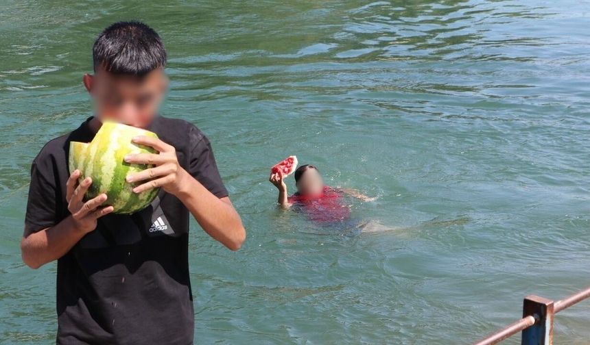Adana'da tehlikeli serinlik! Sulama kanalında yüzüp karpuz yediler